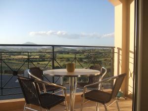 a table with chairs and a coffee cup on a balcony at Mazotos Panoramic Village in Mazotos