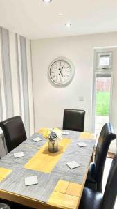 a conference room with a table and a clock on the wall at Folkestone 3 Bedroom home just off M20 in central area private parking in Kent