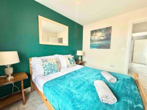 a bedroom with a large bed with a green wall at Folkestone 3 Bedroom home just off M20 in central area private parking in Kent +13 photos