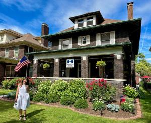 a woman standing in front of a house at The Butler House Bed & Breakfast in Niagara Falls