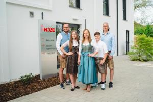 Eine Gruppe von Menschen steht vor einem Gebäude in der Unterkunft Hotel & Appartements Nice Garni - klimatisiert AC- Nähe Legoland Günzburg - Familienfreundlich in Ichenhausen