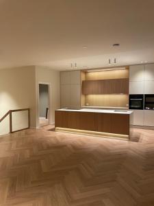 an empty room with a kitchen with wooden floors at Aurora Mansion in Tromsø