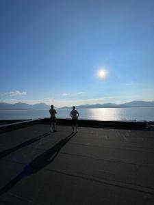 two men standing on a pier looking at the water at Aurora Mansion in Tromsø