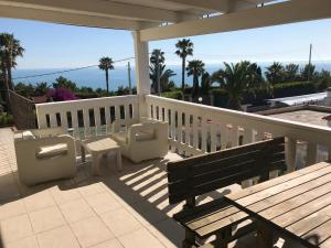 un portico con panchina e sedie sul balcone di Residence CasaNova a Vieste