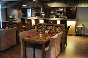 a dining room with a wooden table and a bar at Alpinhotel INzeller in Inzell