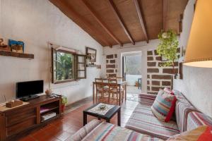 a living room with a couch and a tv at Casa Rural La Cuadra in Hermigua