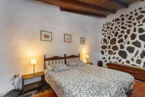 a bedroom with a bed and two lamps on tables at Casa Rural La Cuadra in Hermigua