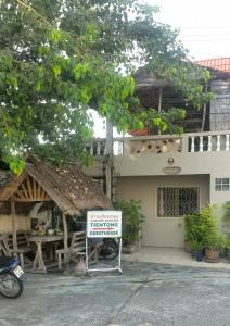 a restaurant with a sign in front of a building at Tientong Guesthouse in Hua Hin