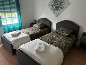 カルカソンヌにあるVilla de Castelli - résidence avec piscineのベッド2台と壁掛け時計が備わるホテルルームです。