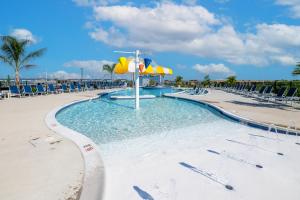 a pool at a resort with chairs and umbrellas at Chincoteague Bay RV Resort & Cottages in Chincoteague
