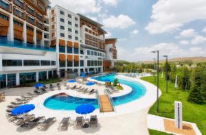 an image of a hotel with a pool and chairs and umbrellas at Radisson Blu Hotel & Spa, Istanbul Tuzla in Istanbul