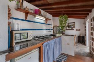 a kitchen with a stove and a microwave at Casa Rural La Cuadra in Hermigua