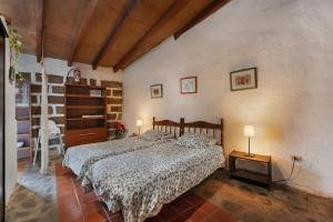 a bedroom with a bed and a table with two lamps at Casa Rural La Cuadra in Hermigua
