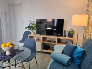 a living room with a couch and a television at The Blue Calla in Las Palmas de Gran Canaria