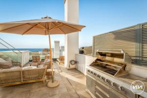 patio con ombrellone e griglia all'aperto di Penthouse Diamond - Private Pool, Terrace, Sea View, Gym & BBQ a Las Lagunas Mijas Altre 51 foto