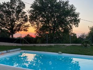 a swimming pool with a sunset in the background at MAISON 119m2 in Revel