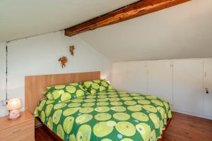 a bedroom with a bed with a green comforter at Antico Forno in Piteglio