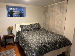 a bedroom with a bed with a black comforter and a window at Private Studio Apartment-Pet Friendly in Downers Grove