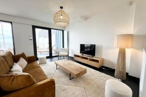 a living room with a couch and a coffee table at Villa d’architecte contemporaine - Vue mer 180 in Larmor-Plage +43 photos