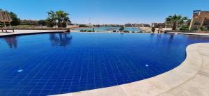 a swimming pool with blue tiles in a resort at El Gouna Waterside, 2-Bd Ground Floor Sleeps 4 Persons in Hurghada