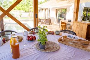a table with a plate of bread and a bottle of juice at Gîtes Lou Hamou in Vagnas