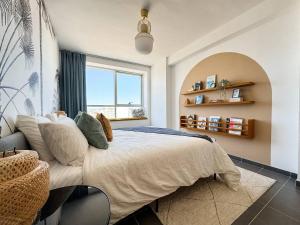 Un dormitorio con una cama grande con ventana. en Elegant Hilton Penthouse, en Charf