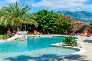 a swimming pool with chairs and umbrellas at Servotel Saint-Vincent in Nice