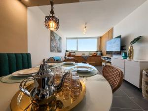 Un comedor con una mesa y una sala de estar. en Elegant Hilton Penthouse, en Charf