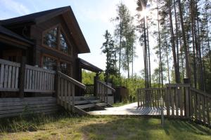 a log cabin with a wooden ramp leading to a house at Villa Viktoriya in Arpolahti