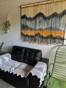 a black leather couch in a living room with a curtain at Pousada Moranga in Carolina