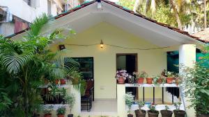 a small house with potted plants on the porch at Jardim De Sanfrancisco in Agonda