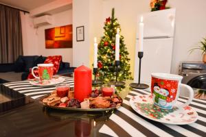 einen Tisch mit einem Teller Essen und einem Weihnachtsbaum in der Unterkunft Royal Accommodation in Bukarest
