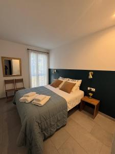 a bedroom with a large bed with towels on it at Apartamento nuevo en el centro con garaje in Cadaqués