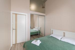 a bedroom with a bed with two towels on it at Shanti barracks apartment #2 by Polo Apartments in Kaunas