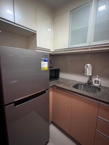Una cocina con frigorífico de acero inoxidable y fregadero. en 81 Newport Blvd Cluster 4 Unit 10C by Rechelle Nunag, en Manila