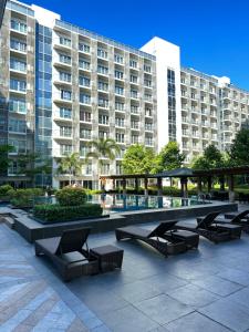 una fila de bancos frente a un gran edificio en 81 Newport Blvd Cluster 4 Unit 10C by Rechelle Nunag, en Manila