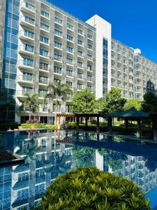 Un gran edificio con una piscina en frente. en 81 Newport Blvd Cluster 4 Unit 10C by Rechelle Nunag, en Manila