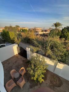 - un balcon avec 2 chaises et des buissons dans l'établissement Ashry, à Al Aqālitah