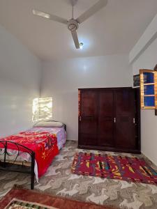 une chambre avec un lit et une armoire en bois dans l'établissement Ashry, à Al Aqālitah 1 autre photo