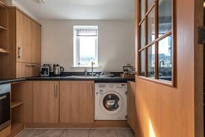 a kitchen with a washing machine and a sink at Apartment in Ashford near outlets and Ashford International Station in Willesborough