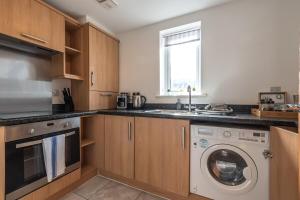 a kitchen with a washing machine and a sink at Apartment in Ashford near outlets and Ashford International Station in Willesborough +13 photos