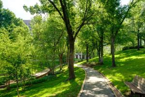 塔尔萨DoubleTree by Hilton Tulsa - Warren Place的公园里有树木和长椅的人行道