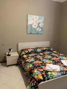 a bedroom with a bed with a colorful comforter at Zar in Omegna