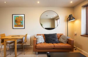 a living room with a couch and a table and a mirror at The Van Gogh - Unique 1 bd -Gold Short Term Stays in Belfast