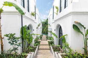 チャングーにあるGreenforest Anahata Villa Resortの白い二つの建物の間の通路