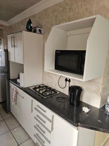 a kitchen with a microwave and a stove top oven at LPM Guests R in Pretoria