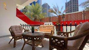 a patio with chairs and a table and a fence at Dream 5BR Villa Escape - Premium Comfort Near Corniche & Abu Dhabi City Center in Abu Dhabi