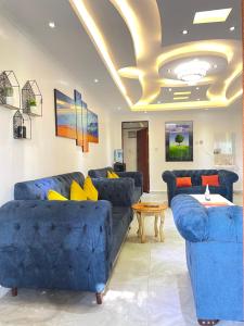 a living room with blue couches and a table at Aberdare Home in Othaya