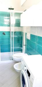 Un baño con inodoro y lavadora. en Affittimoderni Viddalba Bouganville VIBO09, en Viddalba