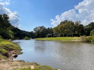 Un río en un campo con árboles al fondo. en Affittimoderni Viddalba Bouganville VIBO09, en Viddalba